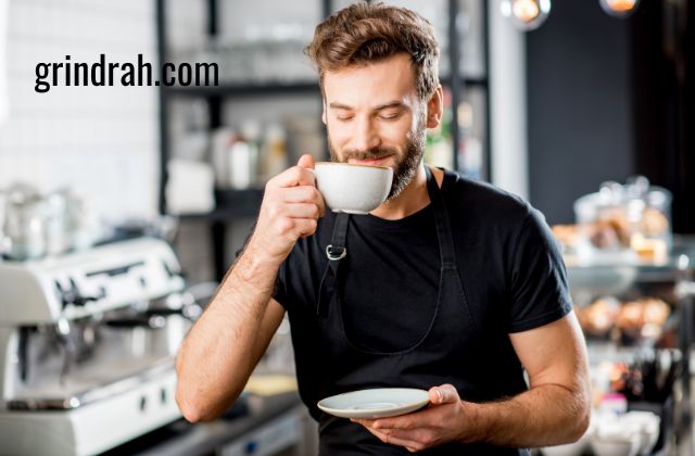 A man drinking coffee in a white mug.